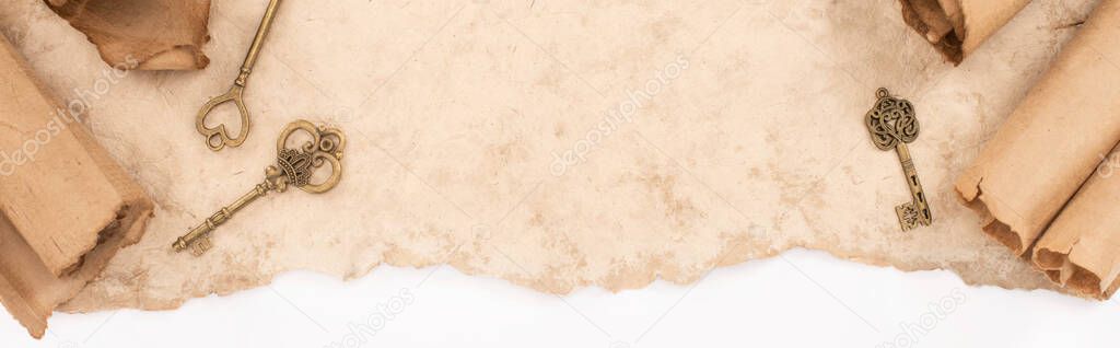 top view of vintage keys on aged paper isolated on white, panoramic shot