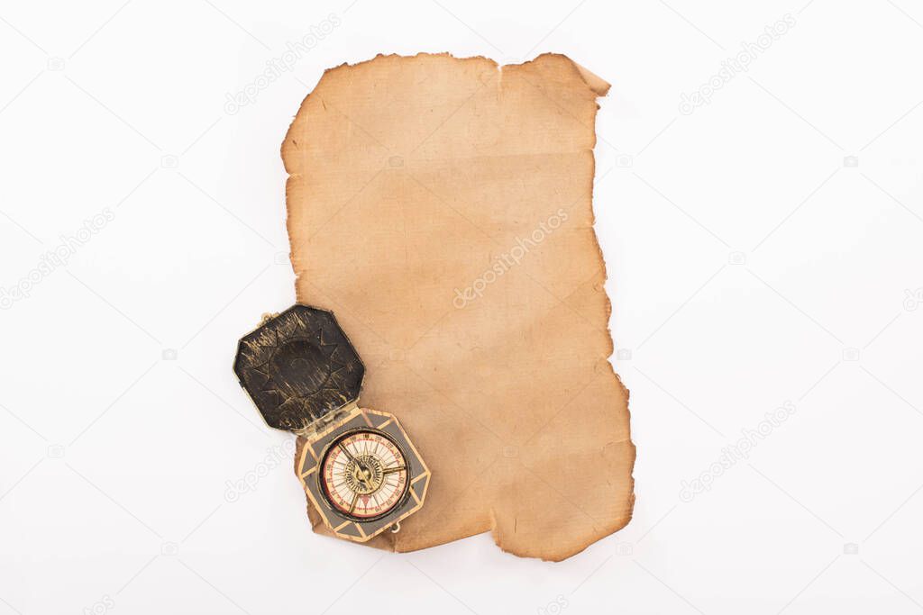 top view of vintage compass on aged empty paper isolated on white