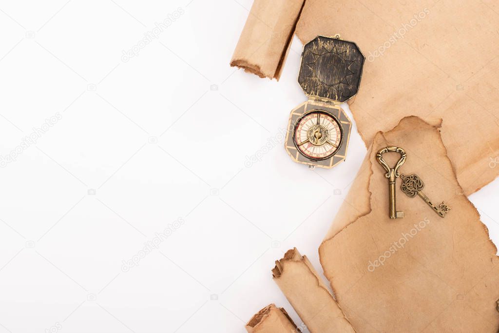 top view of vintage compass, keys and aged parchment paper isolated on white