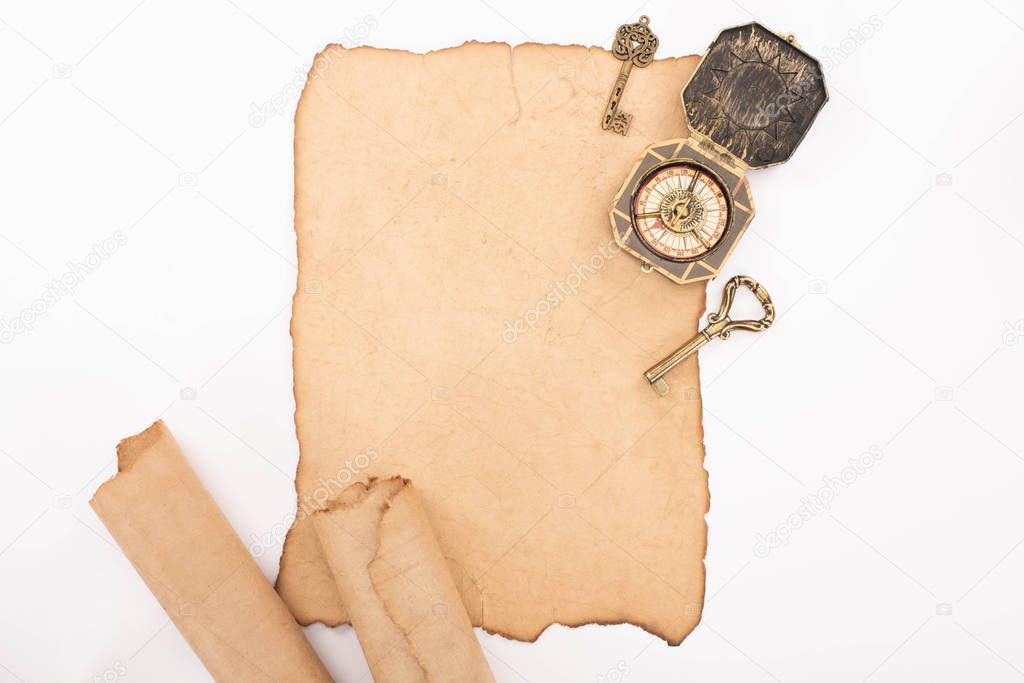 top view of vintage compass, keys and aged parchment paper isolated on white