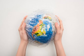 Ausgeschnittene Ansicht einer Frau mit Globus in Plastiktüte auf weißem Hintergrund, Konzept der globalen Erwärmung