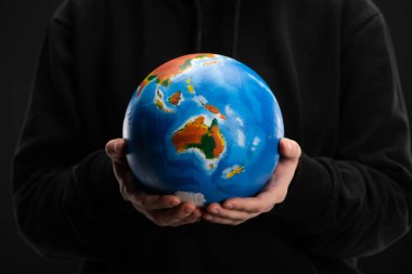 Cropped view of globe in female hands isolated on black, global warming concept clipart