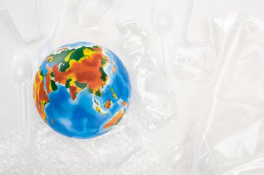 Top view of globe on plastic garbage on white background, global warming concept clipart