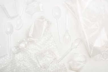 Beyaz arka planda plastik çöplerin üst görünümü, küresel ısınma kavramı