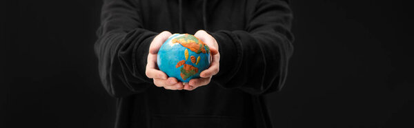 Panoramic view of woman holding plasticine globe isolated on black, global warming concept