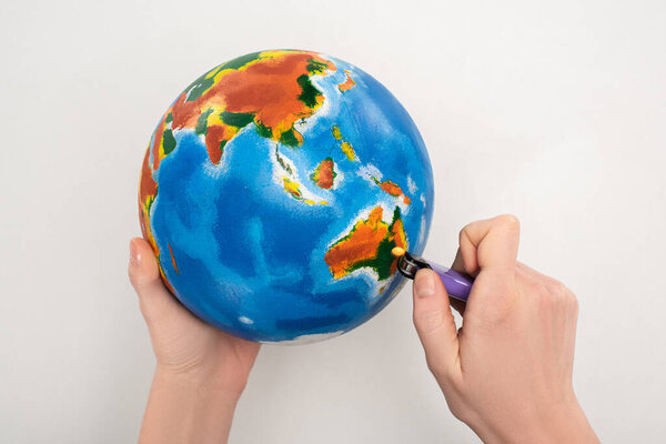 Cropped view of woman setting to fire globe on white, global warming concept