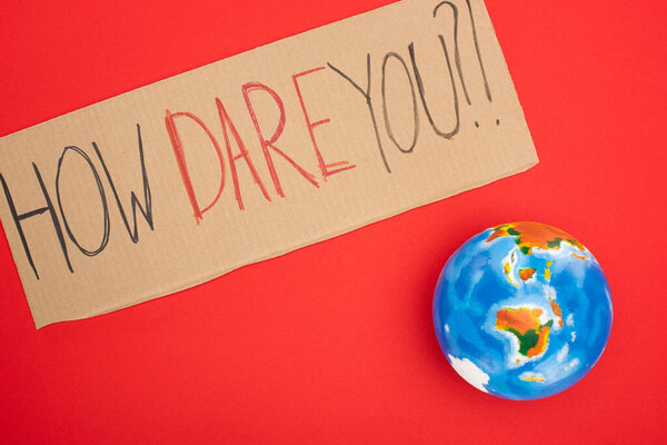 Top view of placard with how dare you lettering and globe on red background, global warming concept