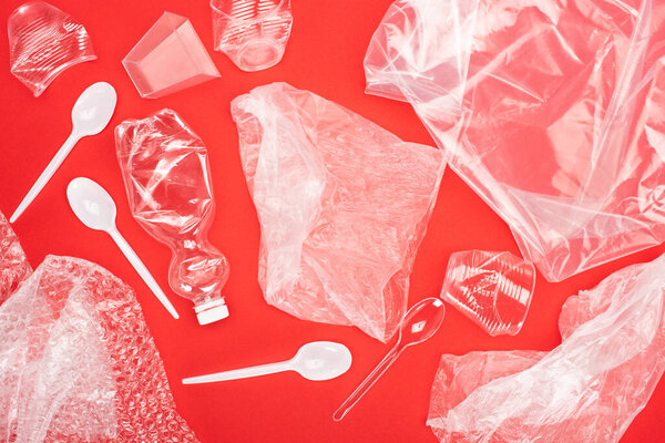 Top view of plastic garbage isolated on red, global warming concept