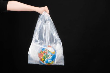 Siyah, küresel ısınma kavramına izole edilmiş plastik çöp ve küre içeren plastik poşet taşıyan kadın görüntüsü