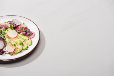 Taze turp salatası, yeşiller ve gri yüzeyde avokado.