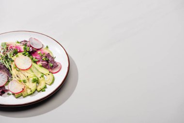 Taze turp salatası, yeşiller ve gri yüzeyde avokado.