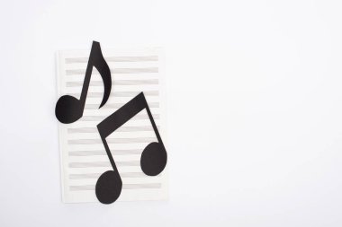 Kağıt kesme notalarının beyaz arkaplandaki müzik kitabındaki üst görünümü