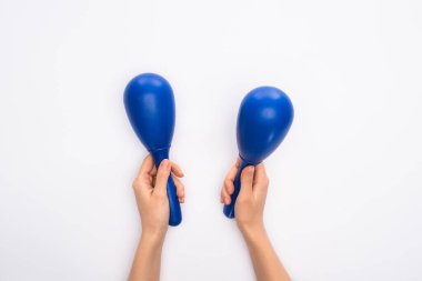 Cropped view of woman holding blue maracas on white background clipart