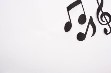 Siyah kağıdın üst görünümü beyaz arkaplanda müzik notalarını keser