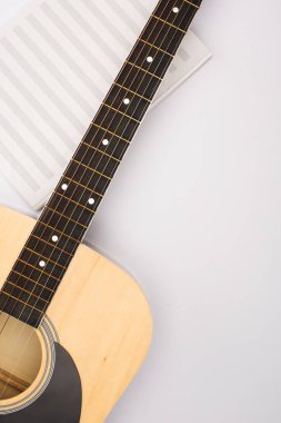 Top view of music book with acoustic guitar on white background clipart
