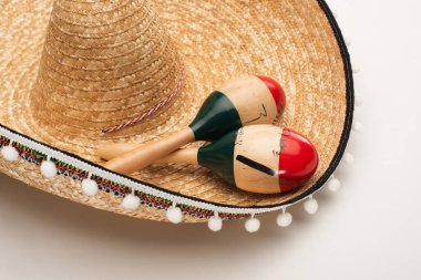 Close up view of wooden maracas on sombrero on white background clipart