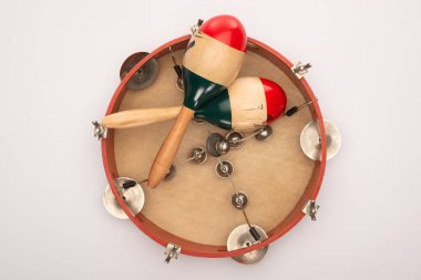 Top view of wooden maracas on tambourine on white background clipart