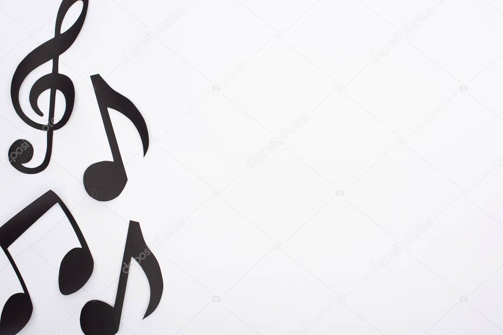 Top view of paper cut music notes on white background