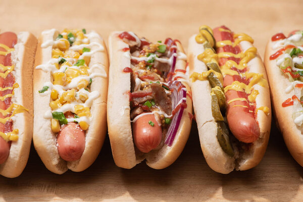 close up view of fresh delicious hot dogs on wooden table