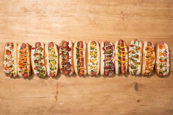 top view of fresh delicious hot dogs on wooden table