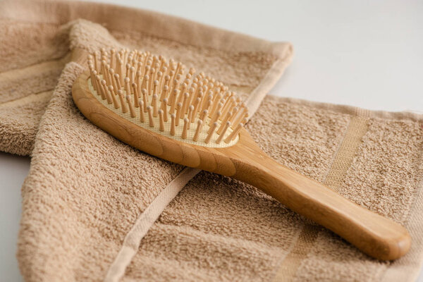 Selective focus of hair brush on towel on grey background, zero waste concept
