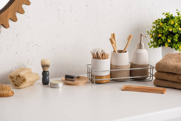 Different beauty and hygiene objects with flowerpot in bathroom, zero waste concept
