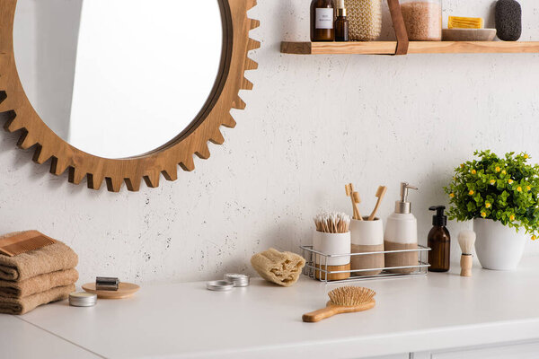Bathroom with different beauty and hygiene objects with flowerpot and mirror, zero waste concept