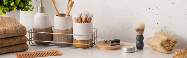 Panoramic view of different beauty and hygiene objects with flowerpot in bathroom, zero waste concept