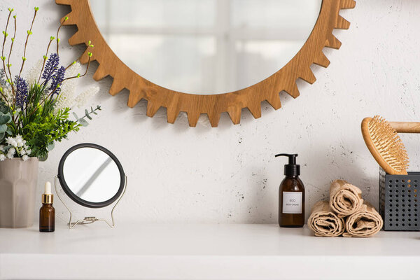 Box with hairbrush, towels near cosmetic products and flowerpot in bathroom, zero waste concept