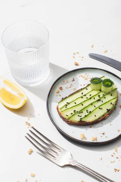 Fresh Cucumber Toast Seeds Served Cutlery Lemon Water White Background — Stock Photo, Image