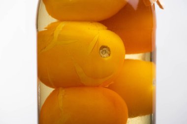 close up view of homemade tasty canned yellow tomatoes in jar isolated on white clipart