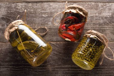 Tahta masadaki kavanozlarda ev yapımı lezzetli turşuların üst görüntüsü
