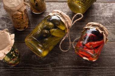 Tahta masadaki kavanozlarda ev yapımı lezzetli turşuların üst görüntüsü
