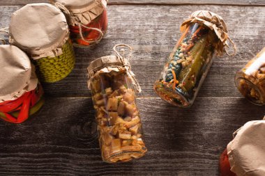 Tahta masadaki kavanozlarda ev yapımı lezzetli turşuların üst görüntüsü