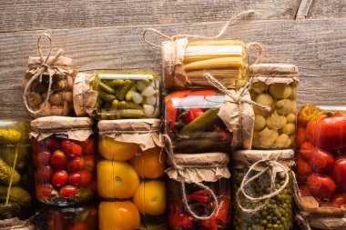 top view of tasty homemade pickles in jars on wooden rustic table clipart