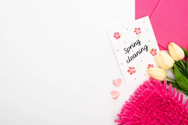 白を基調とした春のクリーニングカード付近のチューリップやピンクのクリーニング用品のトップビュー — ストック写真