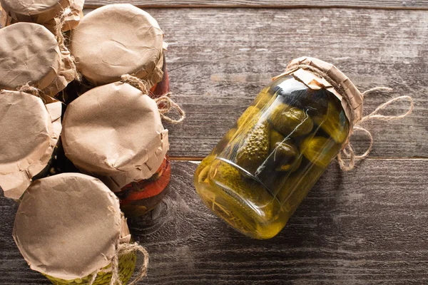木製のテーブルの上に瓶の近くに自家製おいしい缶詰のキュウリのトップビュー — ストック写真