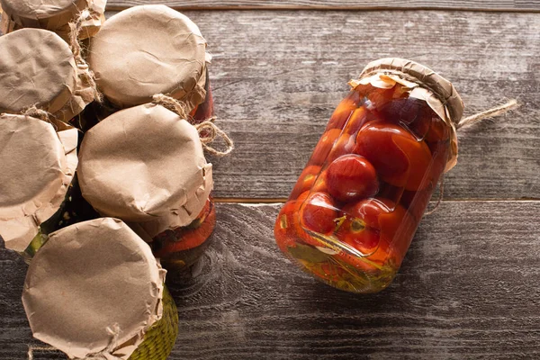 Vista Superior Tomates Enlatados Saborosos Caseiros Perto Frascos Mesa Madeira — Fotografia de Stock