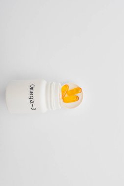 Top view of opened container with omega-3 capsules on white background clipart