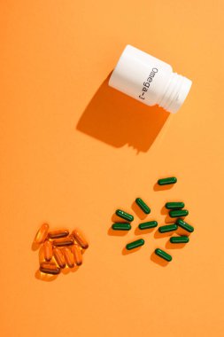 Omega-3 harfli ve turuncu kapsüllü konteynırın üst görünümü 