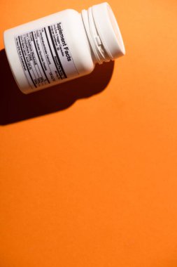 Turuncu arkaplanda beyaz konteynırın yüksek açılı görünümü