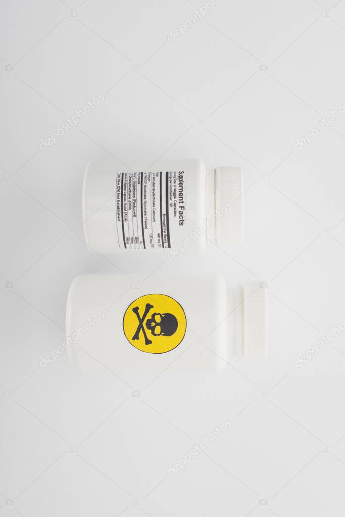 Top view of containers with dietary supplements and poison on white background