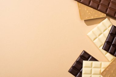 top view of delicious chocolate bars isolated on beige clipart