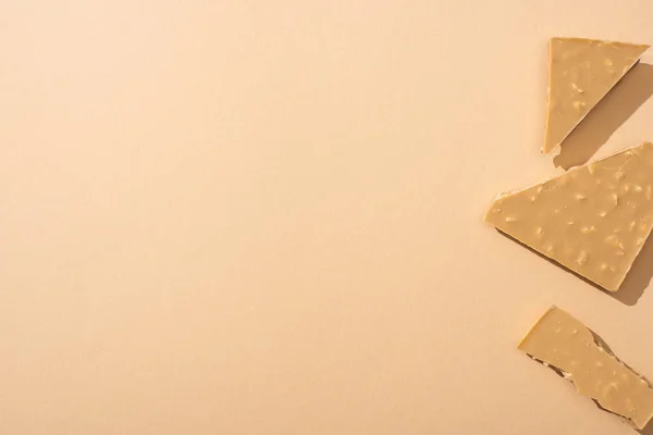 Вид Сверху Вкусный Сломанный Белый Шоколад Бежевом Фоне — стоковое фото