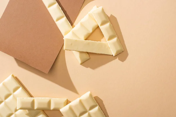 Bovenaanzicht Van Heerlijke Witte Chocoladestukjes Papier Beige Achtergrond — Stockfoto
