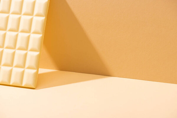 delicious white chocolate bar on beige background