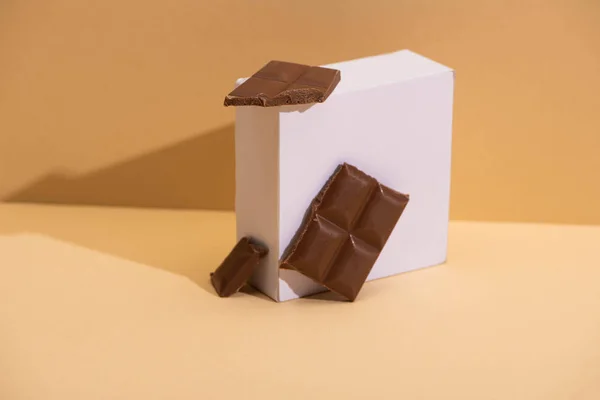 Heerlijke Melkchocolade Stukjes Vierkante Kubus Beige Achtergrond — Stockfoto