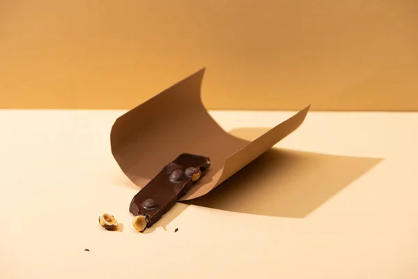 Köstliche Dunkle Schokolade Mit Nussteil Und Papier Auf Beigem Hintergrund — Stockfoto