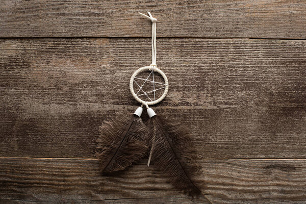 Top view of shamanic dreamcatcher on wooden background