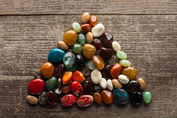 Top view of triangle from fortune telling stones on wooden background